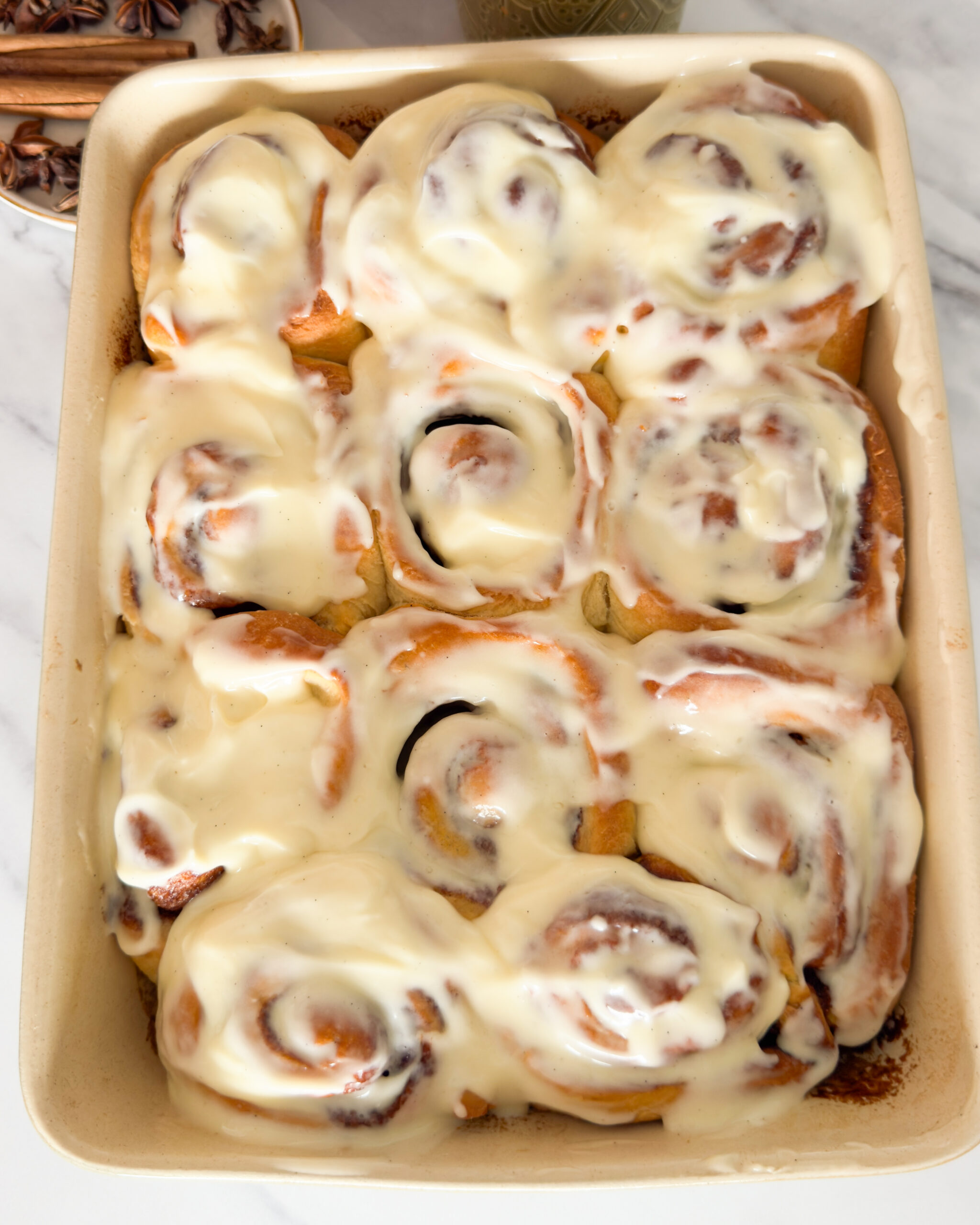 baked cinnamon rolls, covered in vanilla icing